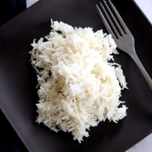 fluffy basmati rice on black plate with fork