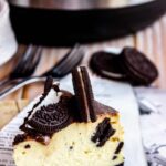 thick slice of Oreo cheesecake with the instant pot in the background