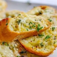 slices of garlic bread with cheese and seasonings