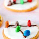 sugar cookie with frosting and m&ms made to look like christmas light decorations