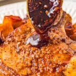 bourbon maple glaze being poured over a garlic smothered pork chop