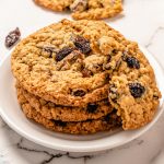 oatmeal raisin cookies stacked with one on top broken in half