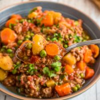 instant pot vegetable hamburger soup in a bowl with a spoonful being lifted