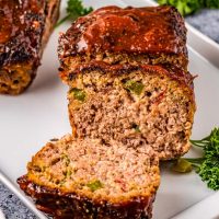 thick glazed meatloaf sliced open revealing green peppers inside