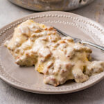 white gravy over biscuits with a fork