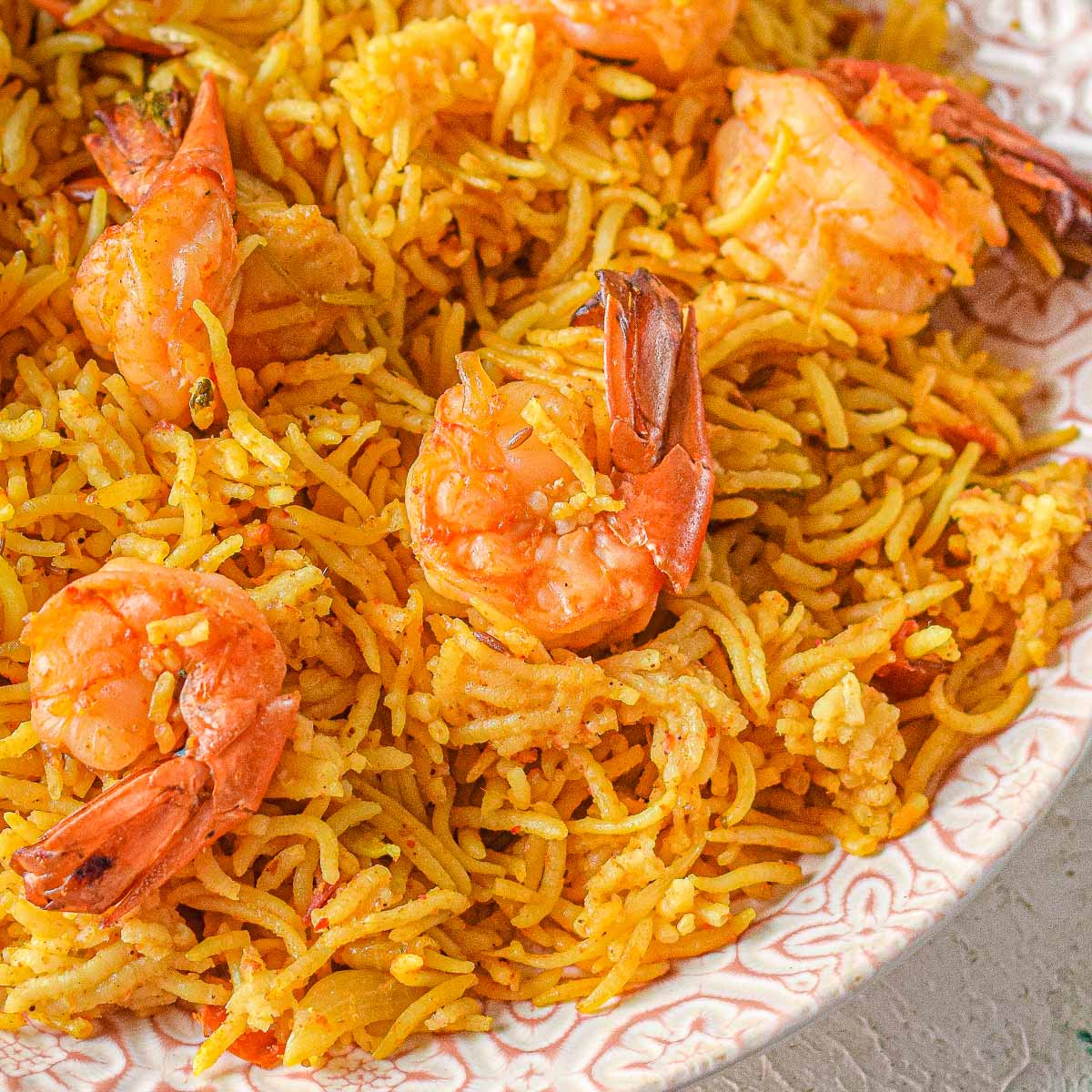 shrimp biryani in a large bowl with rice