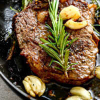 ribeye with garlic and rosemary in a cast iron pan